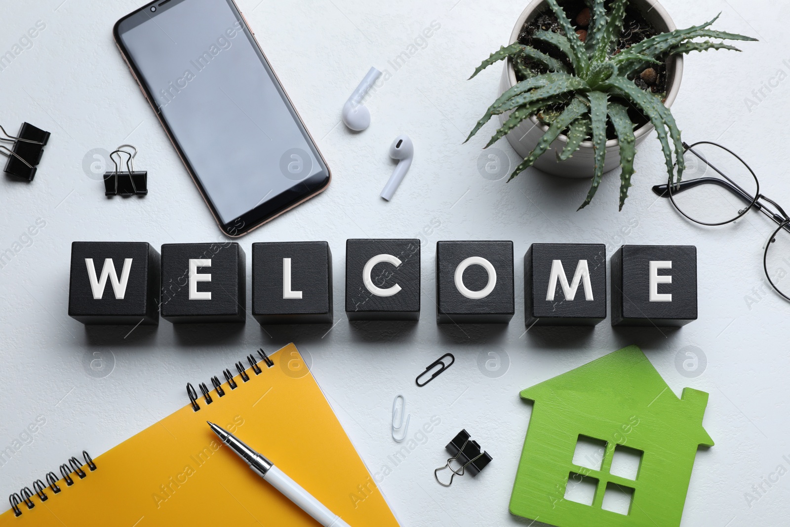 Photo of Flat lay composition of black cubes with word Welcome on white table