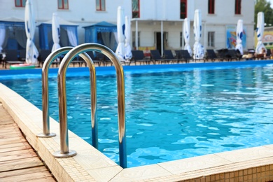 Photo of Modern swimming pool with step ladder at resort