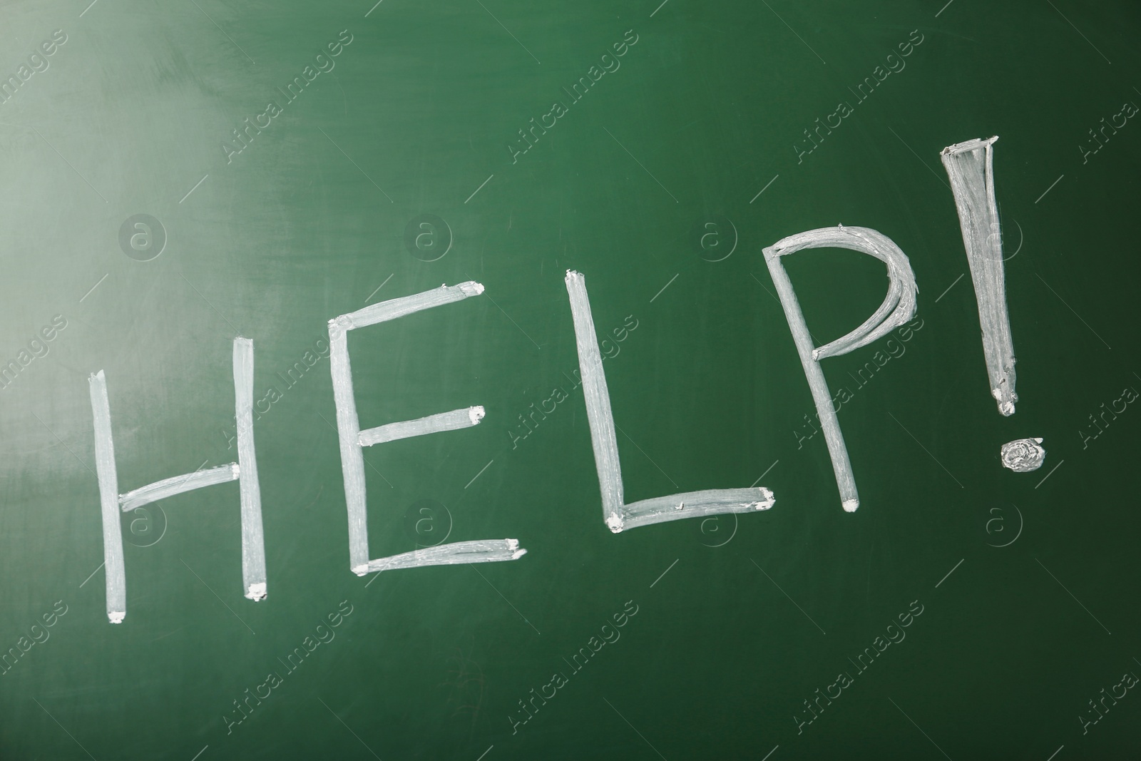 Photo of Word "Help" written with chalk on green board