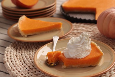 Photo of Piece of fresh homemade pumpkin pie with whipped cream on table