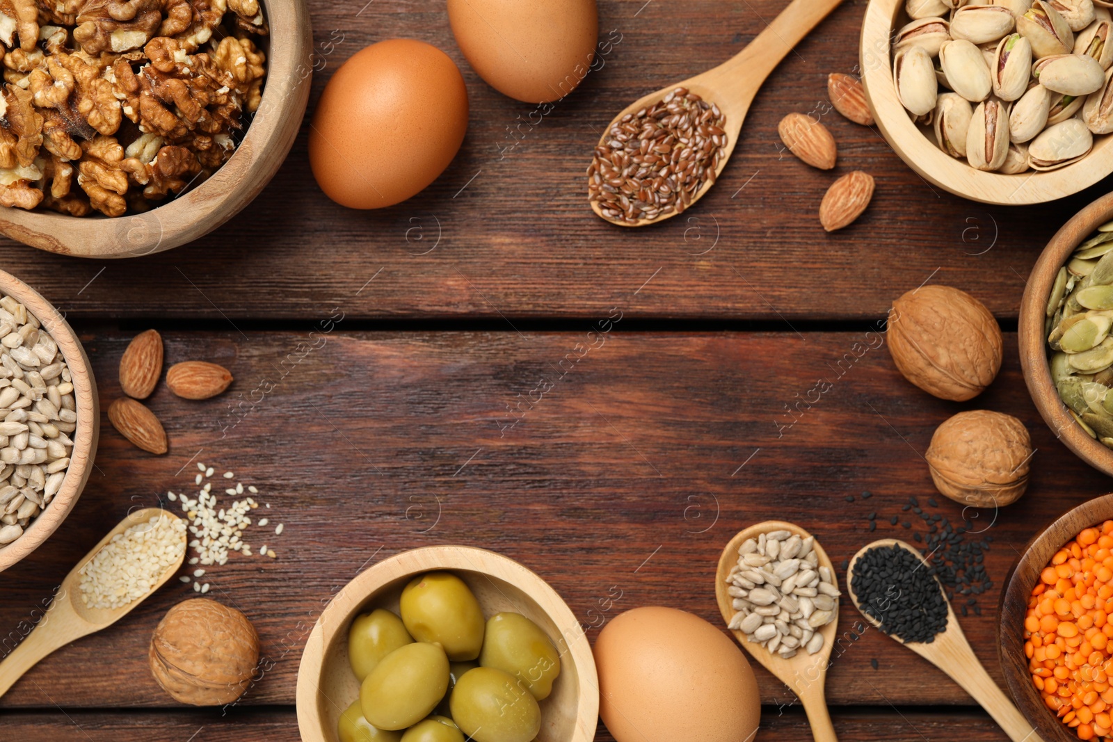 Photo of Frame made of different products high in natural fats on wooden table, flat lay. Space for text