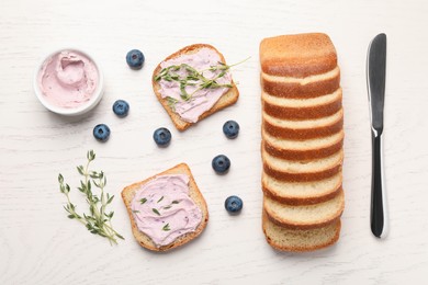 Photo of Tasty sandwiches with cream cheese, thyme and blueberries on white wooden table, flat lay