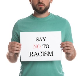 Young man holding sign with phrase Say No To Racism on white background, closeup