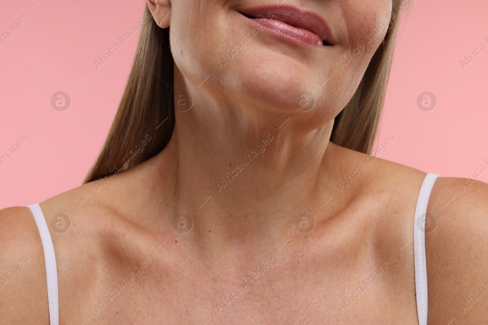 Photo of Mature woman with healthy skin on pink background, closeup