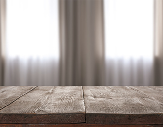 Image of Empty wooden surface and blurred view of modern window 