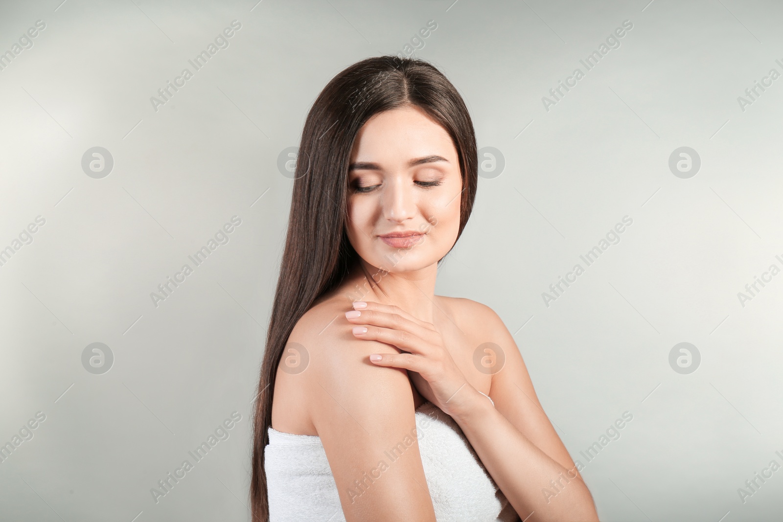 Photo of Portrait of beautiful woman on grey background. Cosmetology and spa