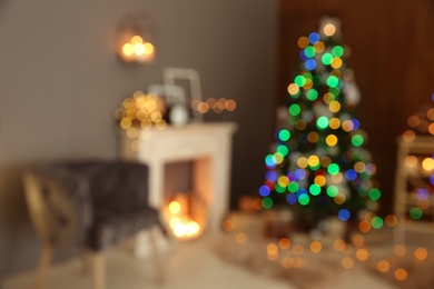 Photo of Blurred stylish room interior with Christmas tree and decorative fireplace