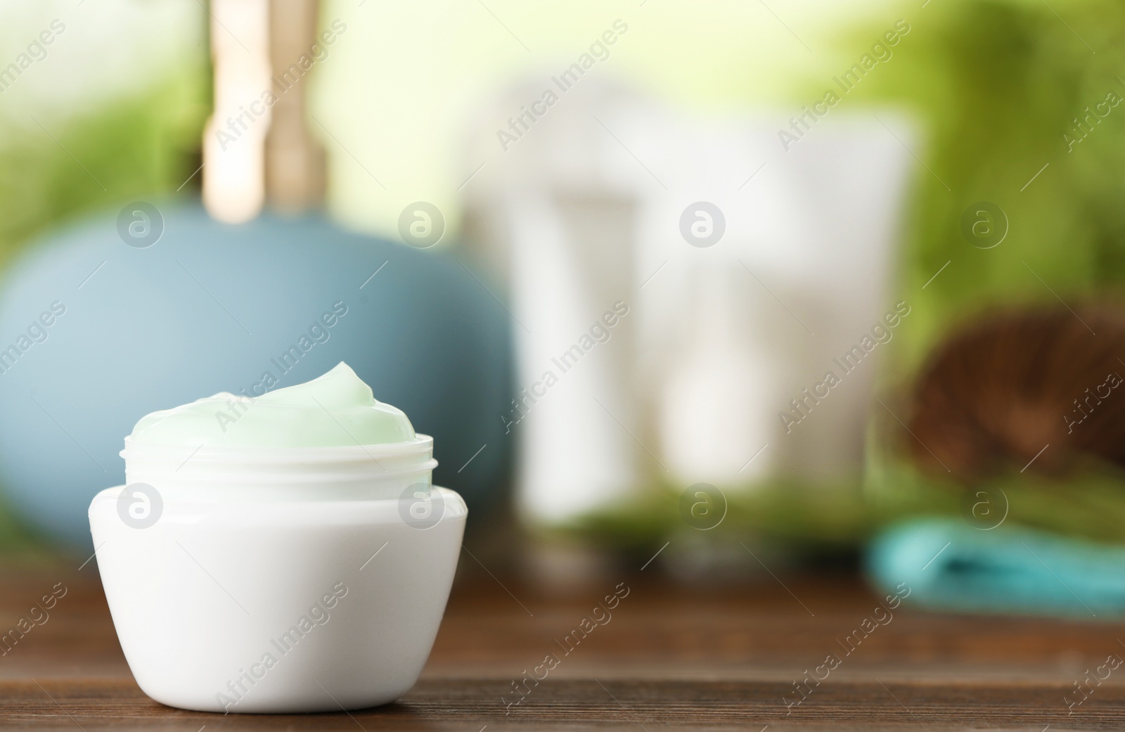 Photo of Jar of body care product on table against blurred background. Space for text