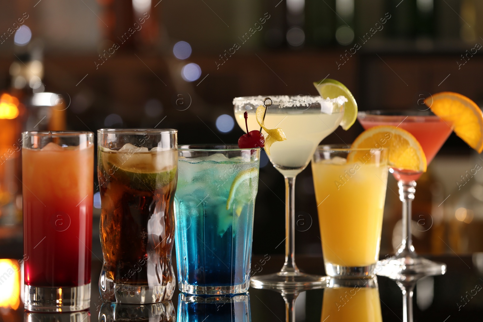 Photo of Different delicious cocktails on counter in bar