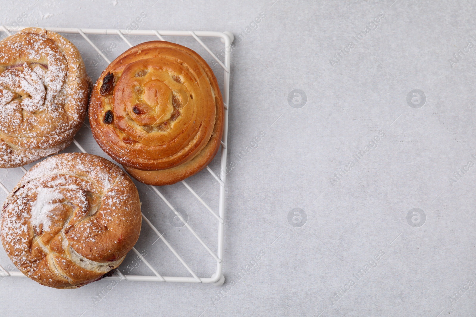 Photo of Different delicious rolls on light table, top view and space for text. Sweet buns