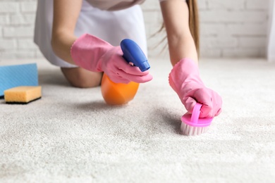 Photo of Chambermaid cleaning carpet indoors