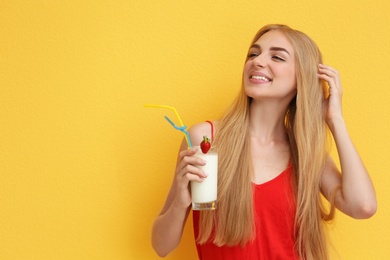 Photo of Young woman with glass of delicious milk shake on color background