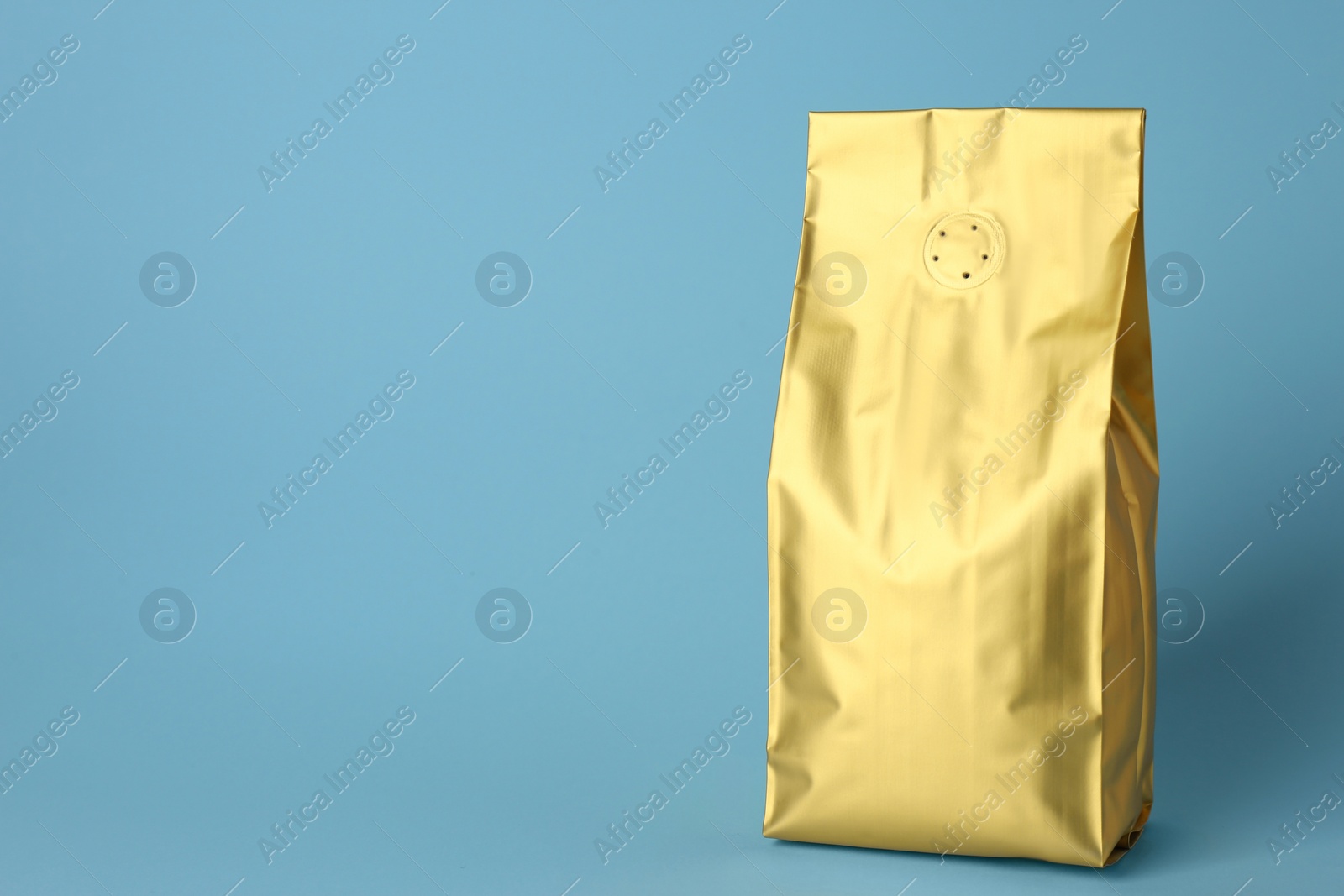 Photo of One blank foil package on light blue background. Space for text