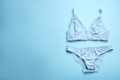Photo of Elegant women's underwear on light blue background, flat lay. Space for text