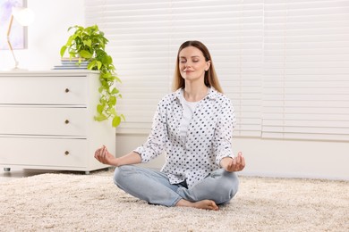 Photo of Woman meditating at home. Harmony and zen