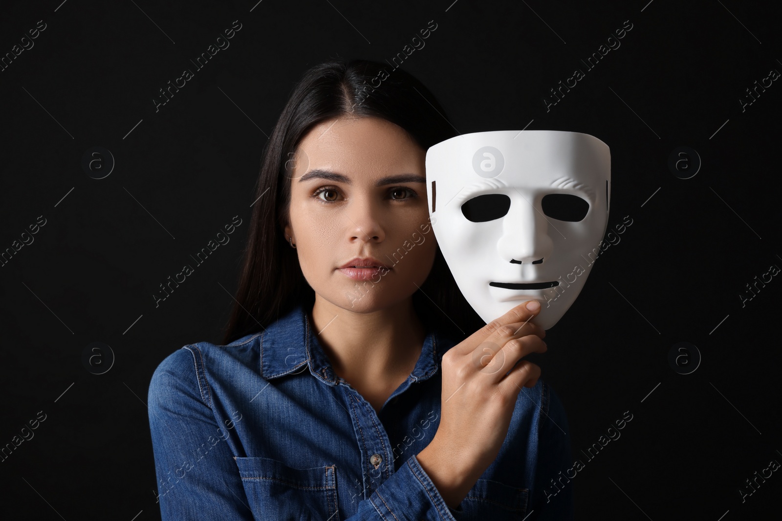 Photo of Multiple personality concept. Woman with mask on black background