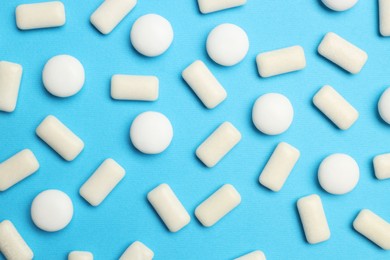 Photo of White bubble gums on blue background, flat lay