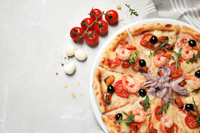 Photo of Tasty pizza with seafood and ingredients on light grey marble table, flat lay