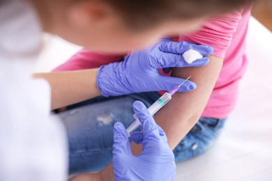 Photo of Little girl receiving chickenpox vaccination in clinic, closeup. Varicella virus prevention