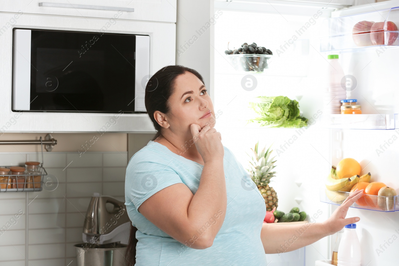 Photo of Woman choosing food from fridge at kitchen. Healthy diet