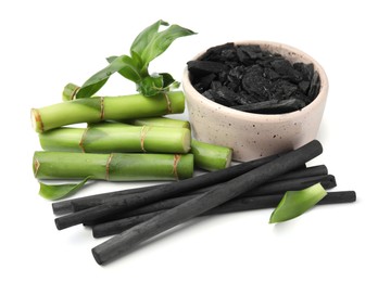 Photo of Fresh bamboo and charcoal on white background