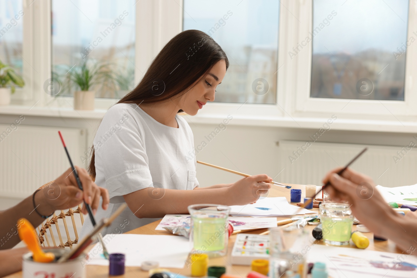 Photo of Group of students attending painting class in studio. Creative hobby