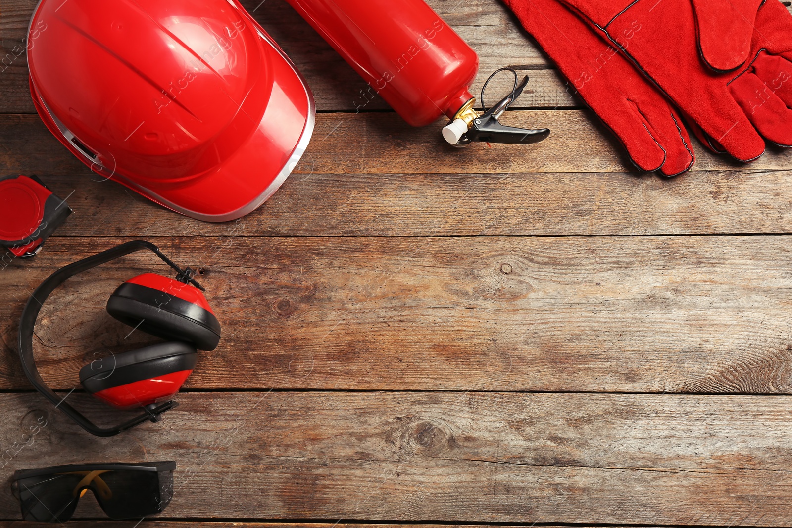 Photo of Flat lay composition with safety equipment and space for text on wooden background