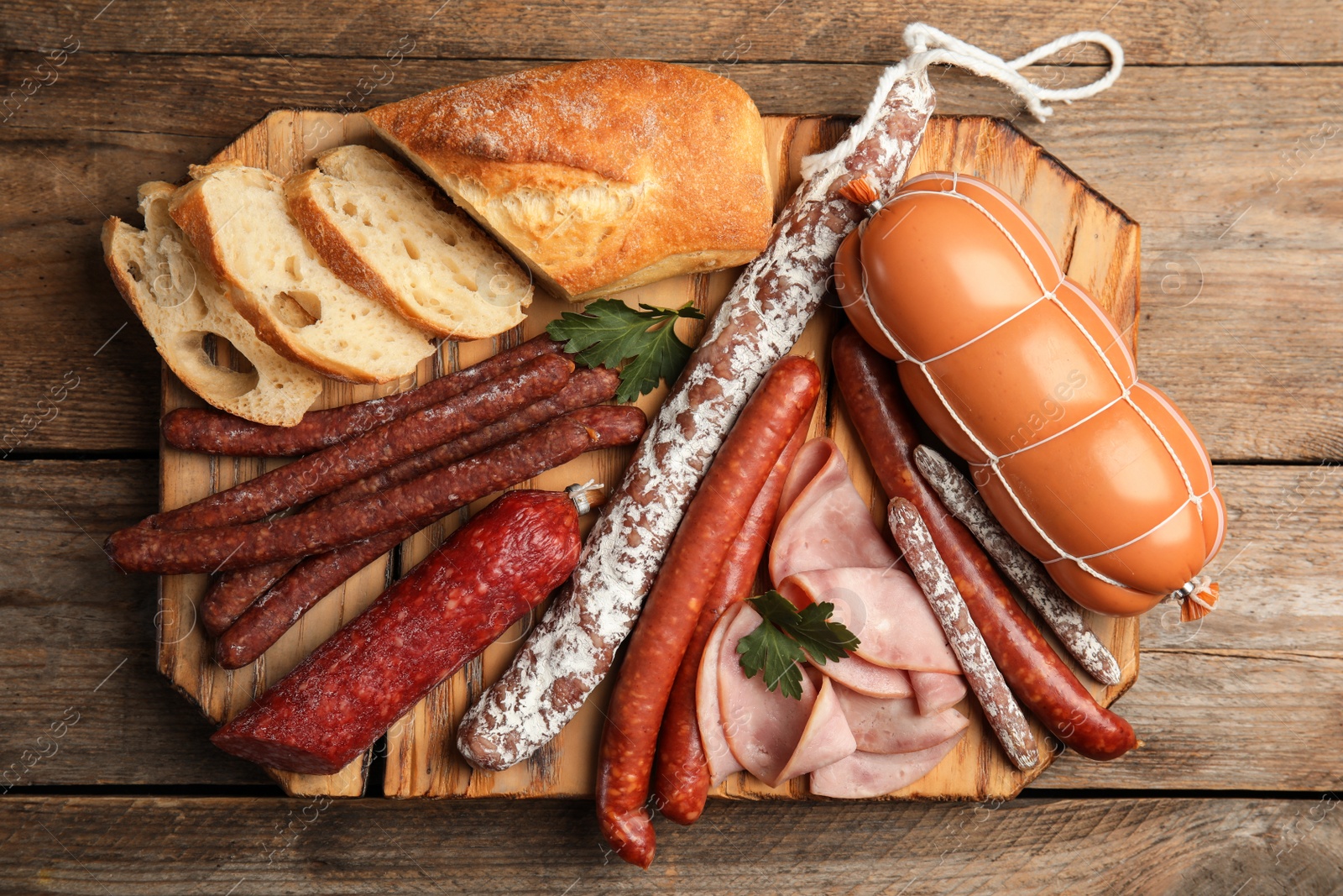 Photo of Different tasty sausages on wooden table, top view