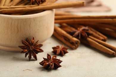 Photo of Bowl with cinnamon sticks and star anise on light table, closeup