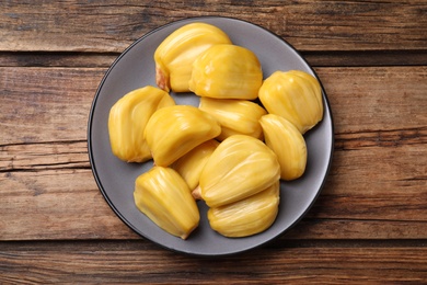 Photo of Delicious exotic jackfruit bulbs on wooden table, top view