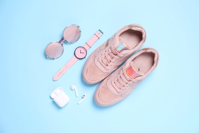 Photo of Flat lay composition with stylish shoes and accessories on light blue background