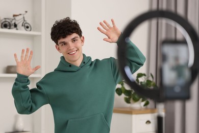 Smiling teenage blogger dancing while streaming at home