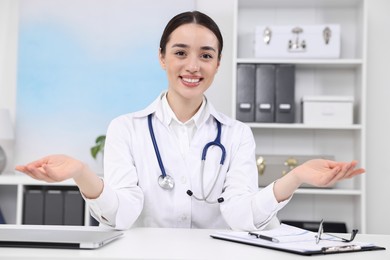 Photo of Medical consultant with stethoscope at table in clinic