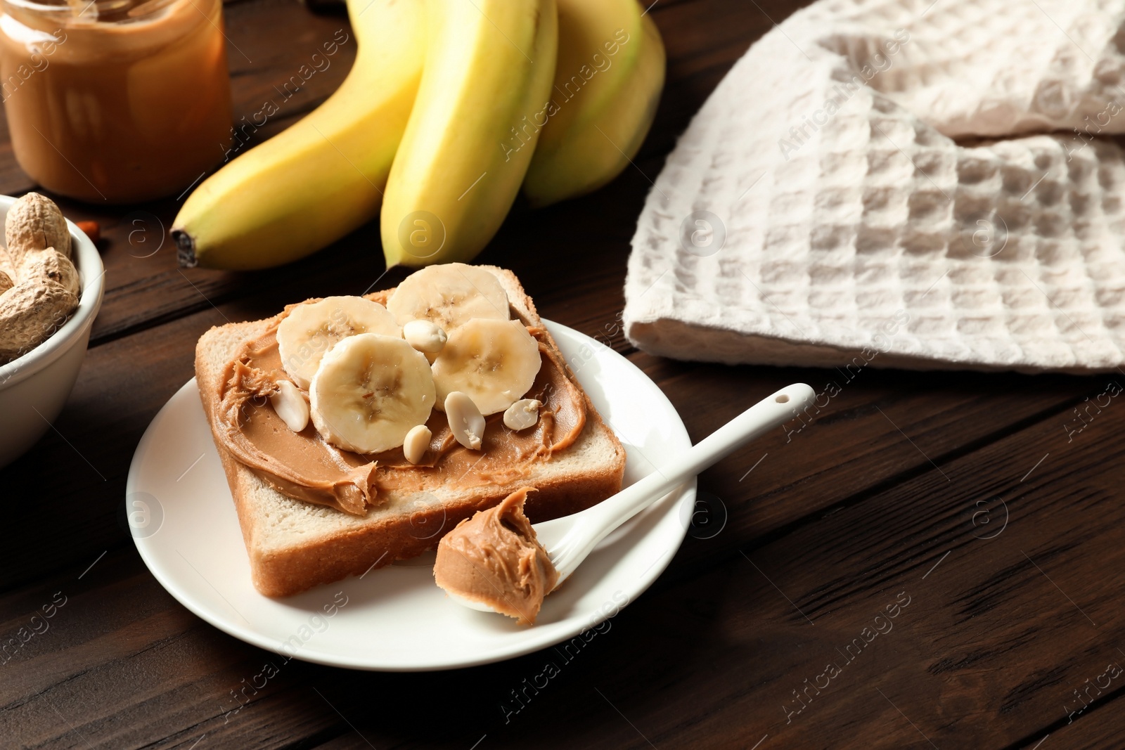 Photo of Toast bread with peanut butter and banana slices on wooden table