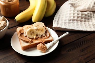 Photo of Toast bread with peanut butter and banana slices on wooden table
