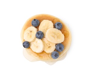 Delicious pancake with banana slices, blueberries and honey isolated on white, top view