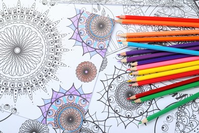 Photo of Pencils on antistress coloring pages, top view