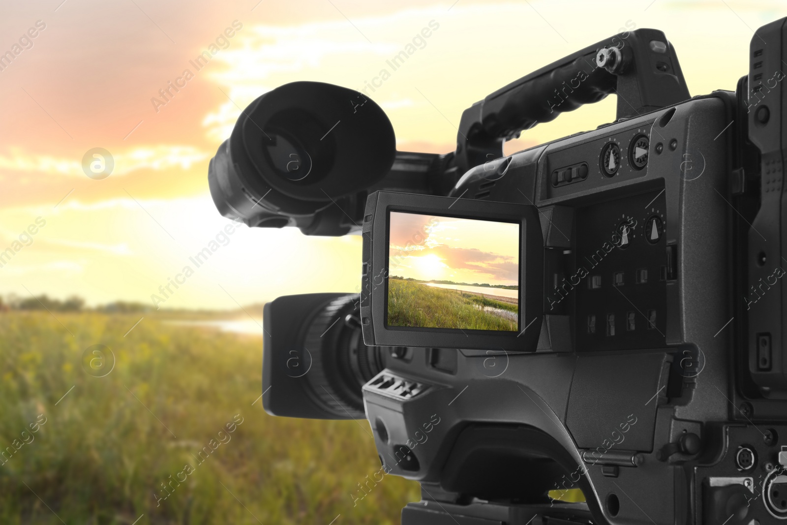Image of Recording beautiful sunset on professional video camera