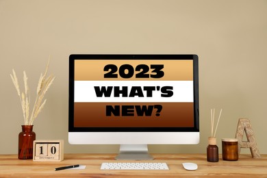 Future trends. 2023 What's New? text on computer monitor. Workplace with wooden table