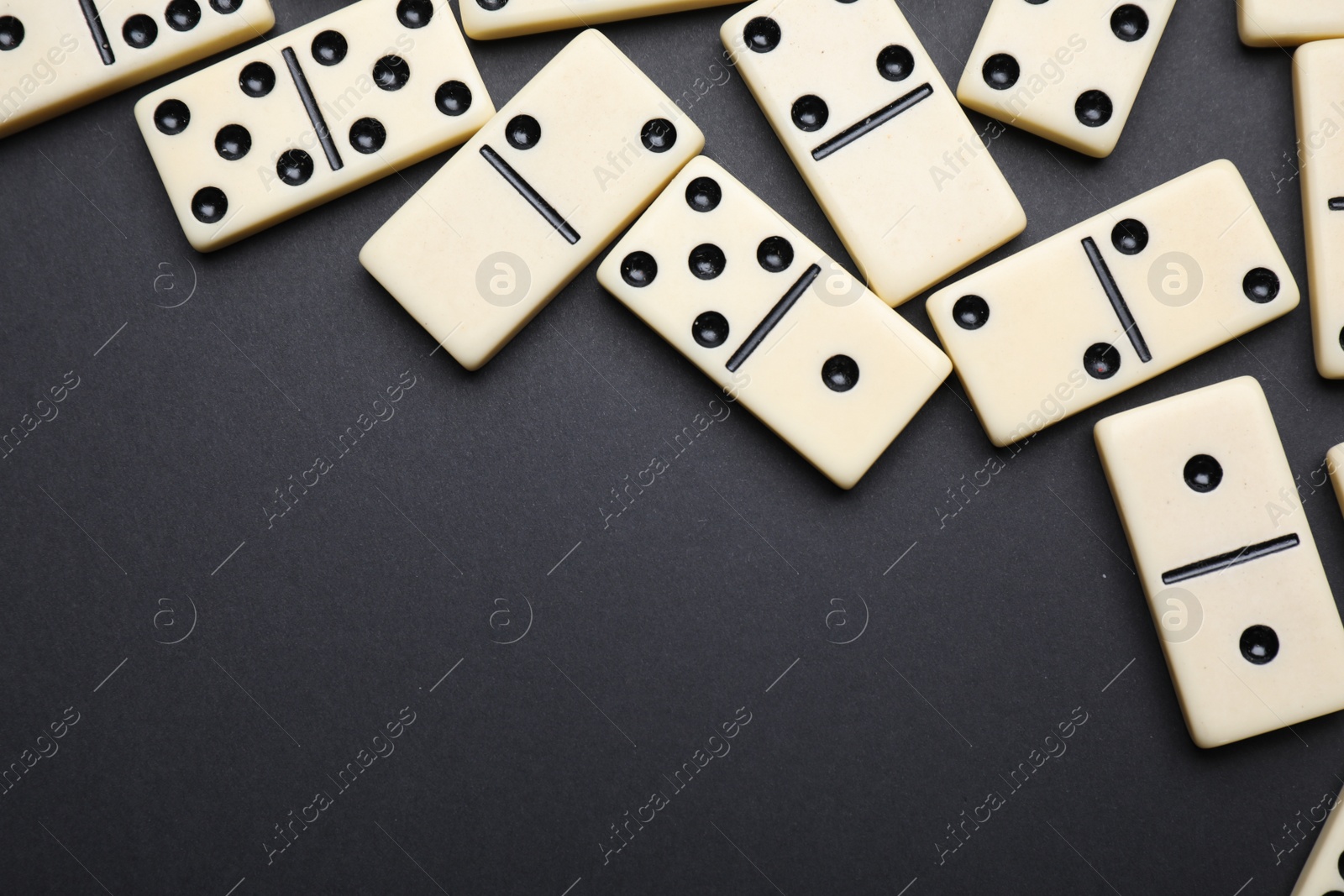 Photo of Classic domino tiles on black background, flat lay. Space for text