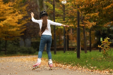 Photo of Cute girl roller skating in autumn park