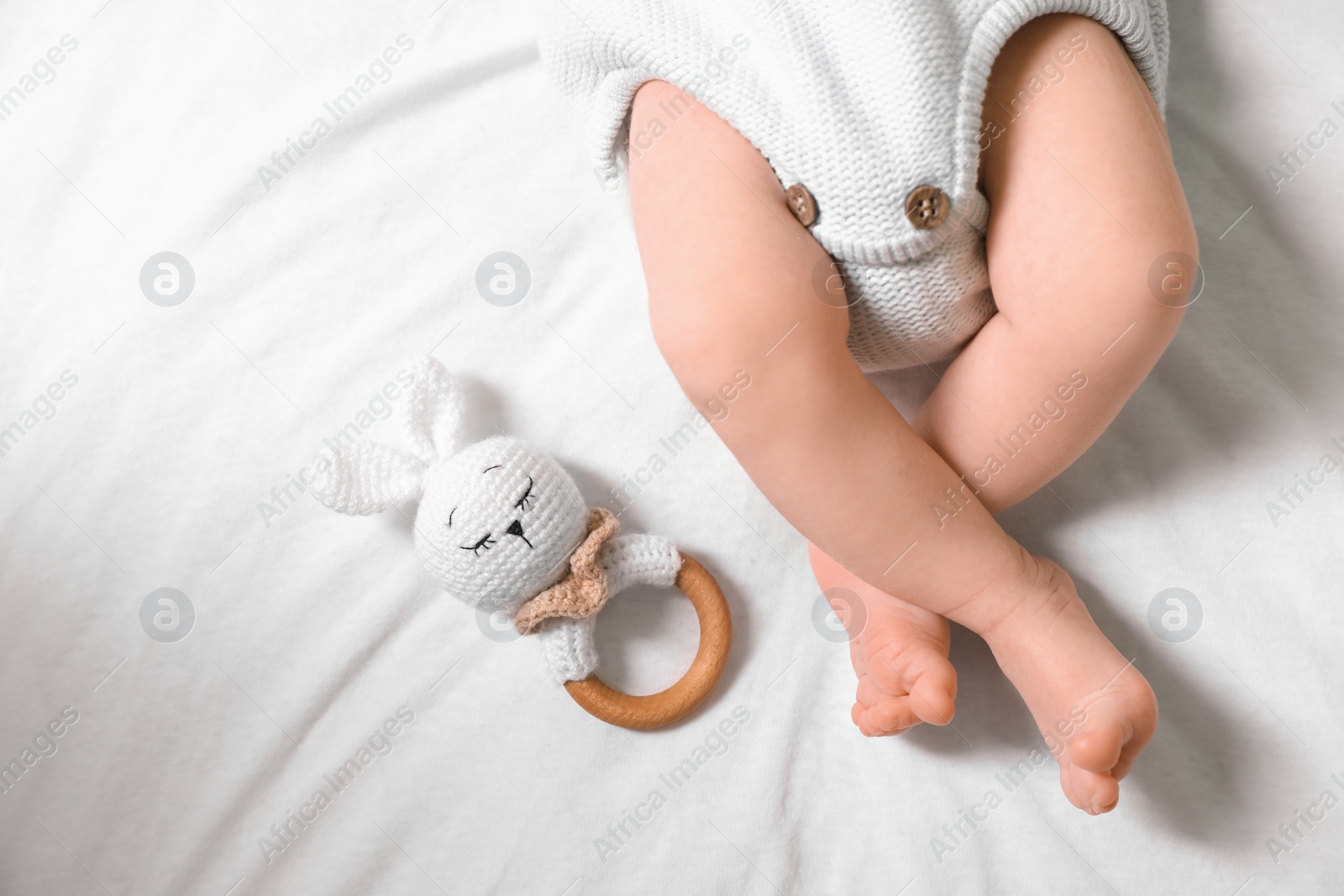 Photo of Newborn baby with toy bunny lying on bed, top view