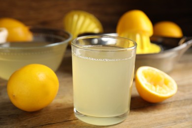 Photo of Freshly squeezed lemon juice on wooden table