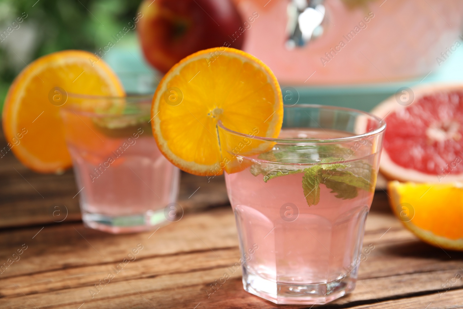 Photo of Delicious refreshing drink with orange and mint on wooden table