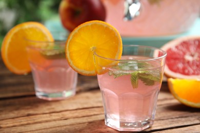 Photo of Delicious refreshing drink with orange and mint on wooden table