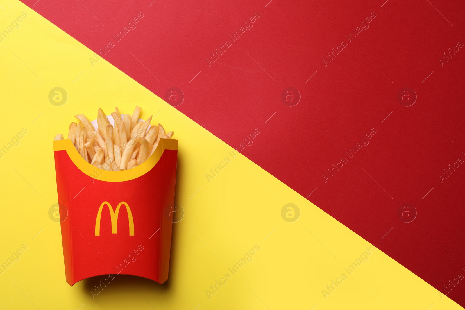 Photo of MYKOLAIV, UKRAINE - AUGUST 12, 2021: Big portion of McDonald's French fries on color background, top view. Space for text