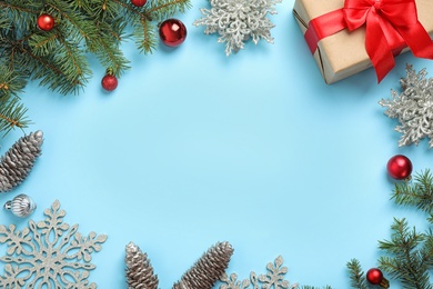 Photo of Fir branches with Christmas decoration on light blue background, flat lay. Space for text