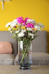 Photo of Beautiful bouquet of Chrysanthemum flowers on grey table indoors. Interior design