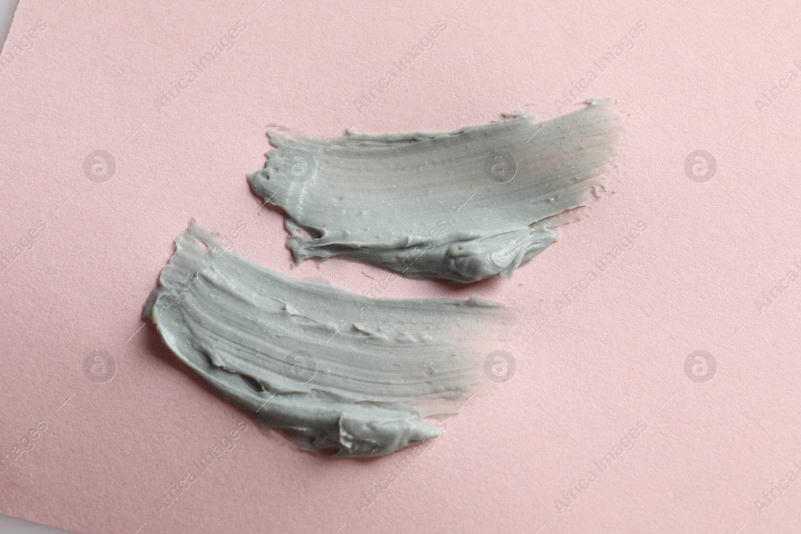 Photo of Samples of face mask on pink background, flat lay
