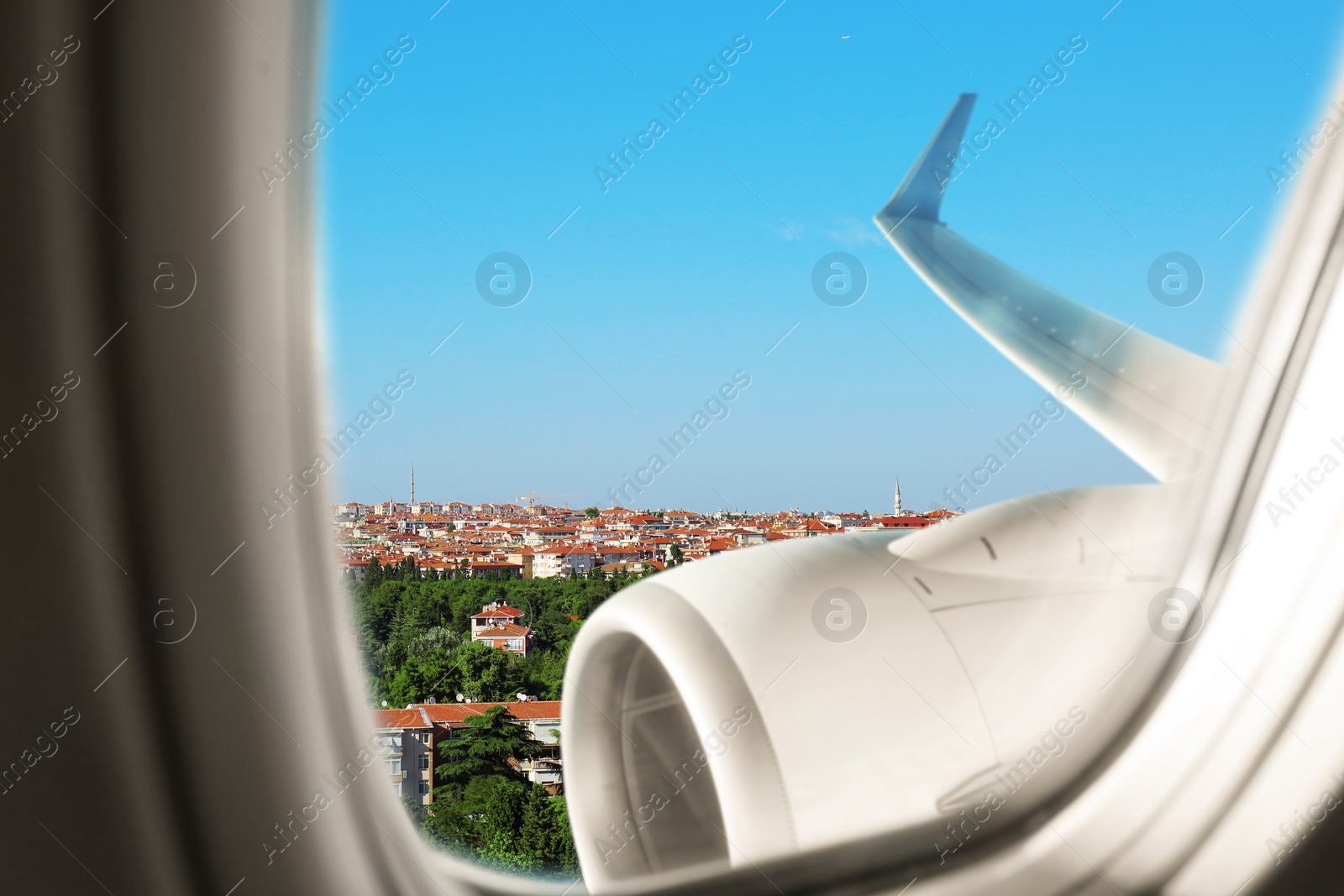 Image of Beautiful view of city with buildings through airplane window during flight